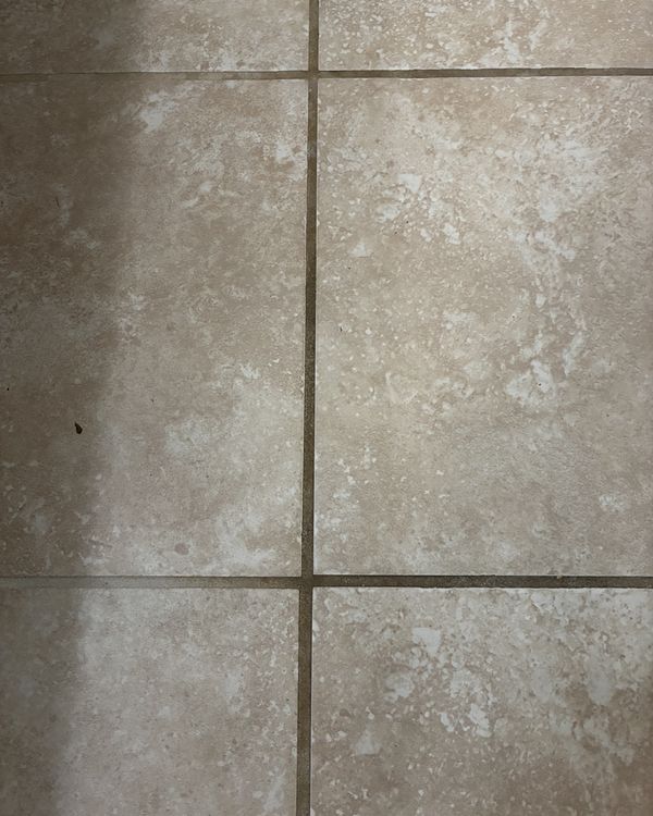 Before: tile floor with dark, dirty grout lines