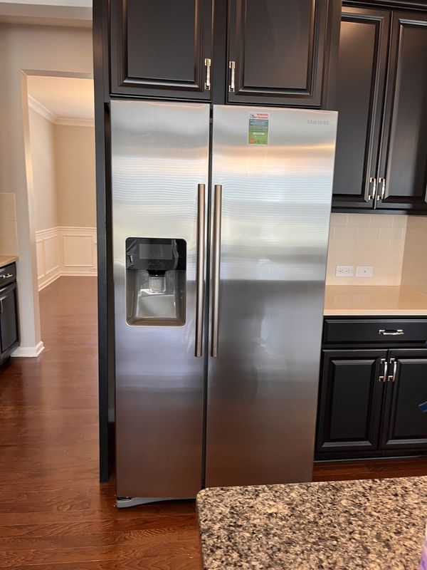 Clean stainless fridge and dark cabinets